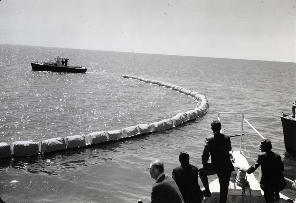 This Marine Pollution Control boat tests an inflatable oil containment boom for a crowd of onlookers.