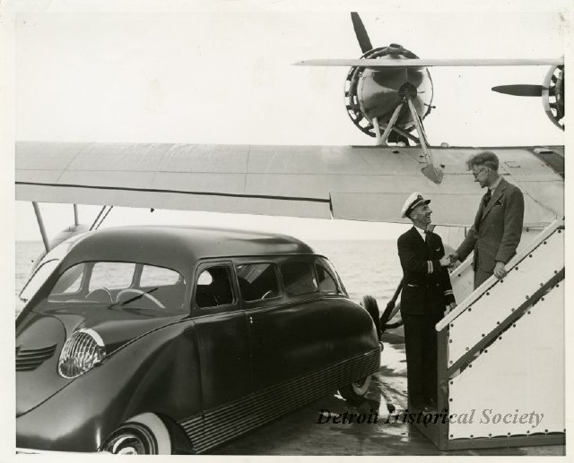 William Bushnell Stout descending the steps of an airplane to a waiting Scarab (1937).