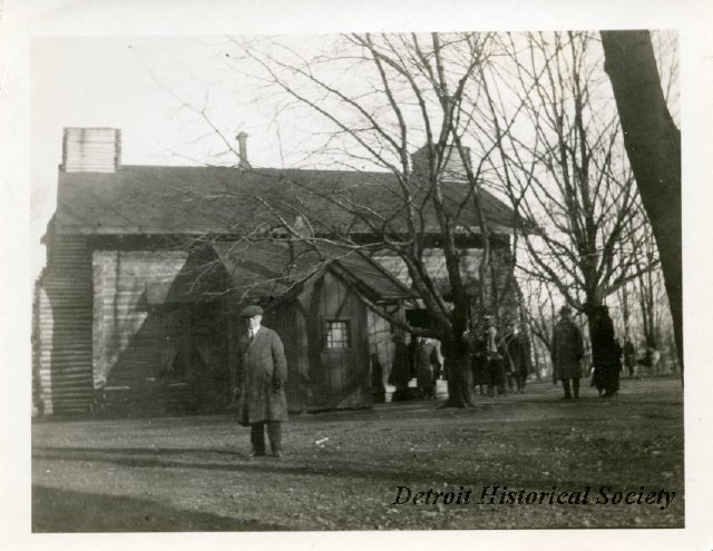 Man in front of Palmer Park Log Cabin, 1923 - 2013.045.132